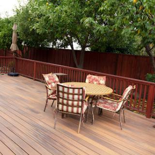 A cozy outdoor seating area on a wooden deck, surrounded by trees.