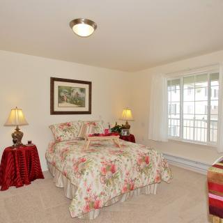 A cozy bedroom with floral bedding and warm lighting.