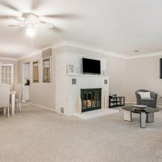 A spacious living room with a fireplace, television, and adjacent dining area.