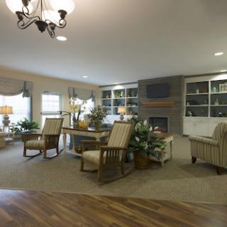 A cozy living room with comfortable seating, a fireplace, and decorative plants.