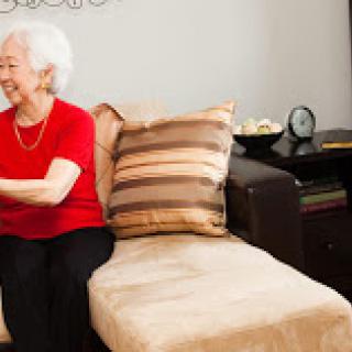 An elderly woman enjoying a moment of joy in her cozy living room.