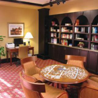 A cozy library corner with a puzzle table and bookshelves.