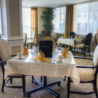 An elegant dining area set for tea, featuring cozy seating and well-arranged table settings.