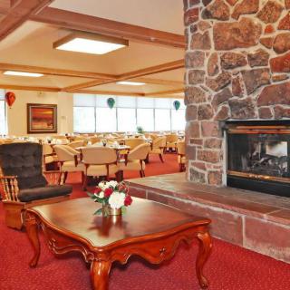 A cozy restaurant interior featuring a stone fireplace and comfortable dining area.