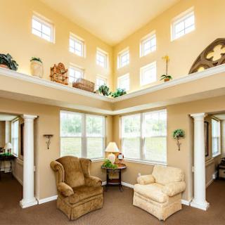 A bright and cozy living room with high ceilings, abundant natural light, and comfortable seating.