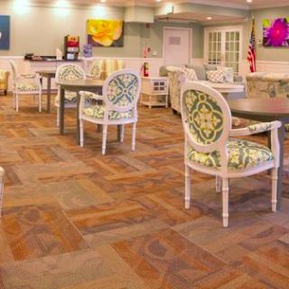 A cozy lounge area with patterned chairs and tables, accented by colorful artwork on the walls.