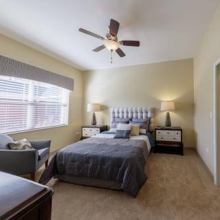 A modern bedroom with a comfortable bed, stylish nightstands, and a ceiling fan.