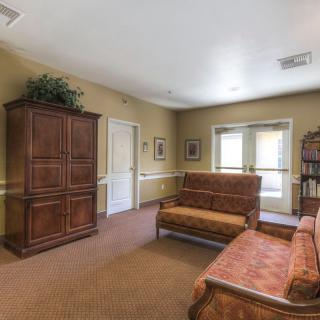 A cozy living room featuring traditional furniture, including a sofa, cabinet, and bookshelf.