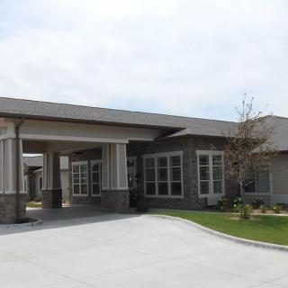 A modern building with a covered entrance and driveway.