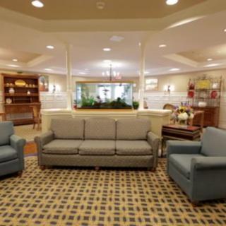 A cozy living room with a sofa and two armchairs arranged around a decorative carpet.
