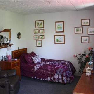 A cozy bedroom with purple-themed decor and wall art.