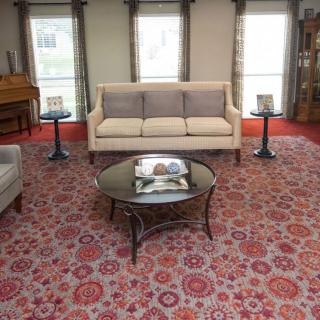 A cozy living room with a sofa, coffee table, and decorative carpet.