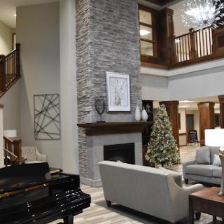 A stylish living room featuring a cozy fireplace, modern furnishings, and festive holiday decor.