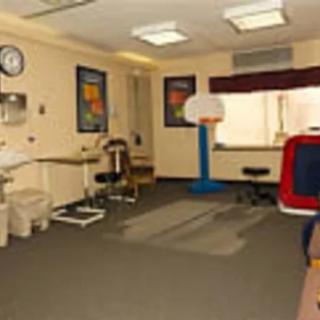 A clinic room equipped with medical and exercise equipment for therapy.