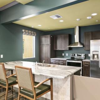A modern kitchen with sleek cabinets, a marble countertop, and stainless steel appliances.