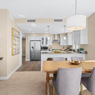 A bright and modern open-concept kitchen and dining area featuring contemporary furniture and elegant finishes.