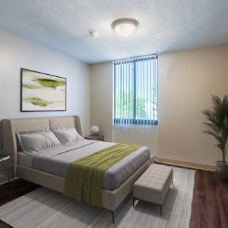 A modern bedroom featuring a stylish bed with green accents, complemented by natural light and decorative elements.