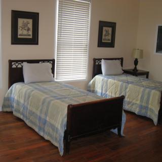 A cozy bedroom with twin beds, decorated in a classic style.
