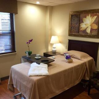A serene and calming massage room with a neatly arranged therapy bed, soft lighting, and soothing decor.