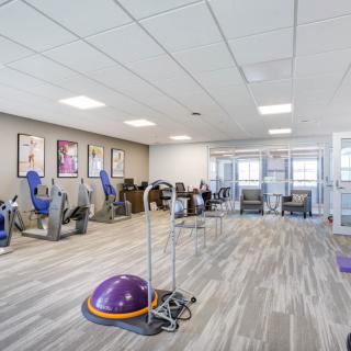 A modern gym with various exercise equipment and an open, well-lit layout.