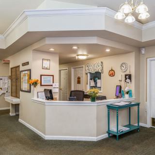 A welcoming office reception area with a central desk and bright lighting.