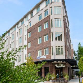 A modern hotel building with a blend of brick and glass facade in an urban setting.