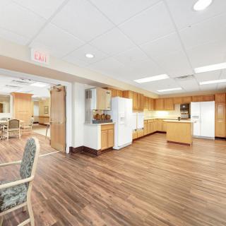 A spacious kitchen area featuring wooden floors, cabinets, and modern appliances.