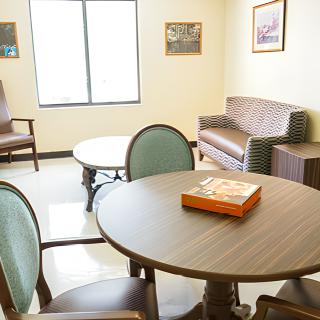 A cozy living room with a round table, chairs, and a sofa.