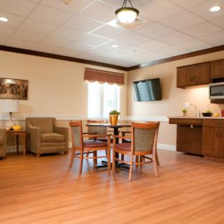 A cozy living area with a table, chairs, and a kitchenette.