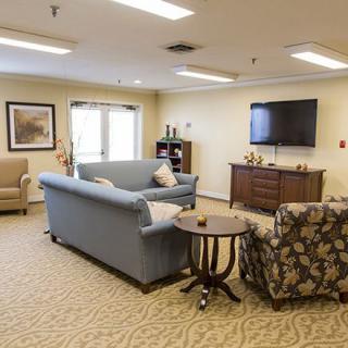 A cozy living room with sofas, an armchair, a television, and tasteful decor.