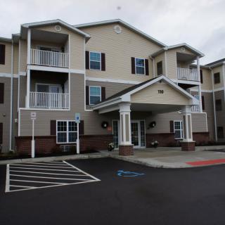 A modern residential apartment building with balconies and a welcoming entrance.