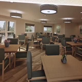 A well-lit dining room with neatly arranged tables and chairs.