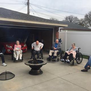 A group of seniors enjoying an outdoor gathering in a backyard setting.
