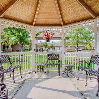 A cozy gazebo with outdoor seating on a sunny day.