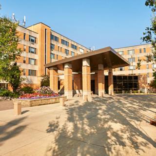 A modern building with a prominent entrance surrounded by landscaping.
