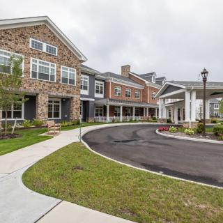 Exterior view of a residential building with a stone facade and driveway.