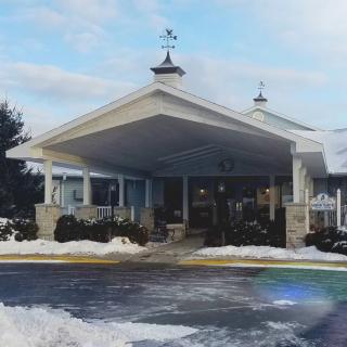 A cozy building entrance surrounded by snow under a clear winter sky.