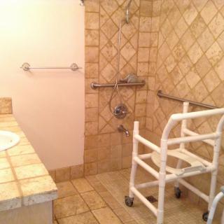 Accessible bathroom with grab bars and a shower walker.