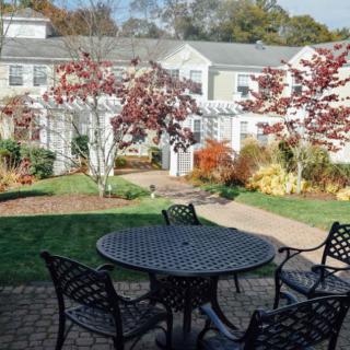 A peaceful garden patio with autumn foliage and outdoor seating.