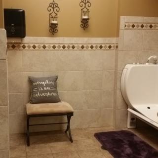 A well-decorated bathroom with a bench, urinal, and decorative elements.