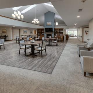 A modern and spacious lounge area featuring comfortable seating, tables, and stylish lighting fixtures.