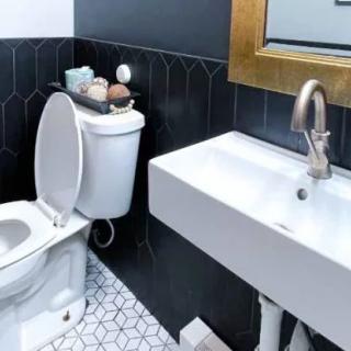 A modern bathroom featuring a sleek sink and toilet with stylish tile flooring.