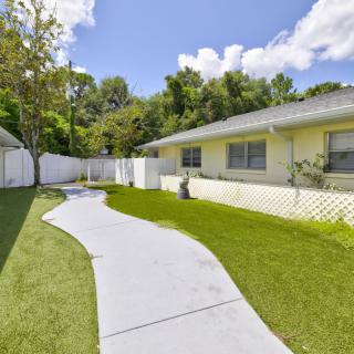 A serene backyard garden with a winding sidewalk and well-maintained lawn.