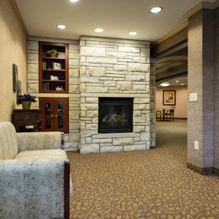 A cozy living room featuring a modern stone fireplace and comfortable seating.