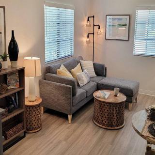 A cozy and modern living room with a gray sofa, stylish lamps, and decorative elements.