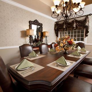 A beautifully set dining room table with an elegant chandelier and classic decor.