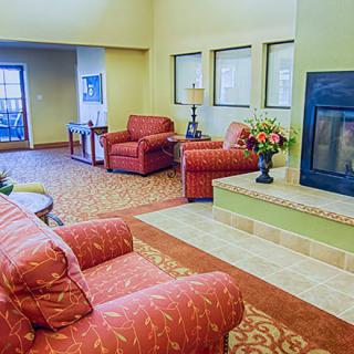 A cozy living room with red upholstered furniture and a fireplace.