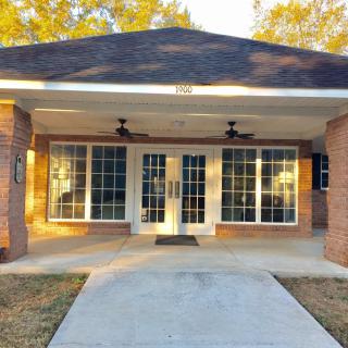 Front view of a house with large windows and a covered porch.