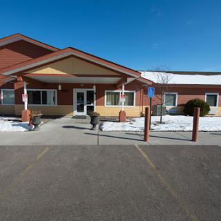 A residential facility entrance during winter, featuring a snow-covered pathway.