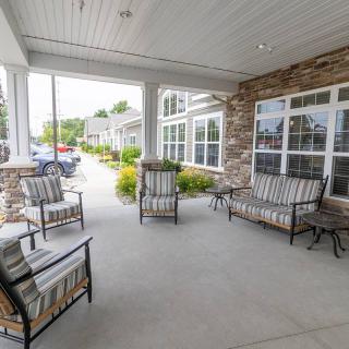 A cozy porch area with comfortable seating and a view of the driveway.